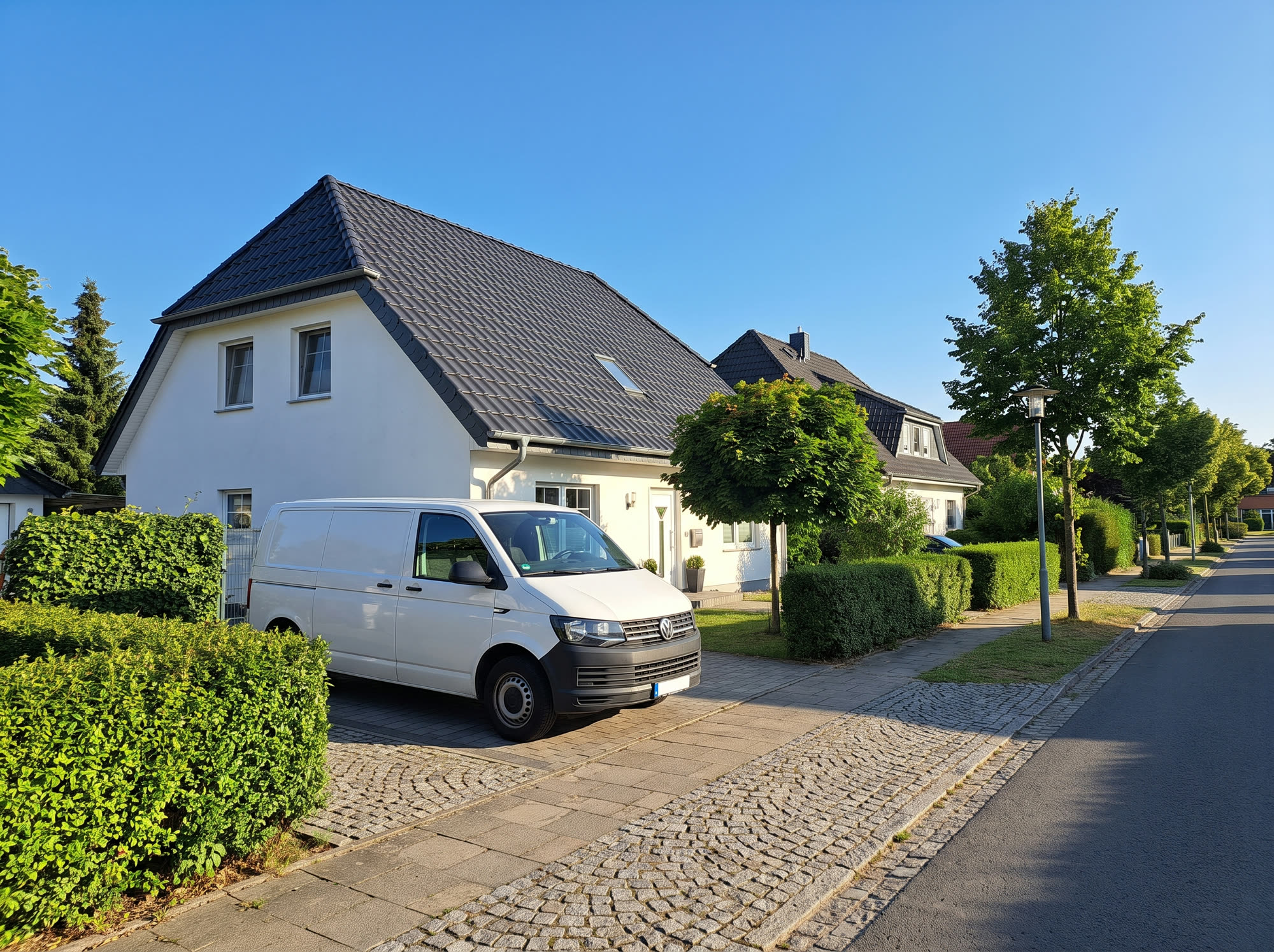 Firmenfahrzeug vor einem Einfamilienhaus mit neuem Dach